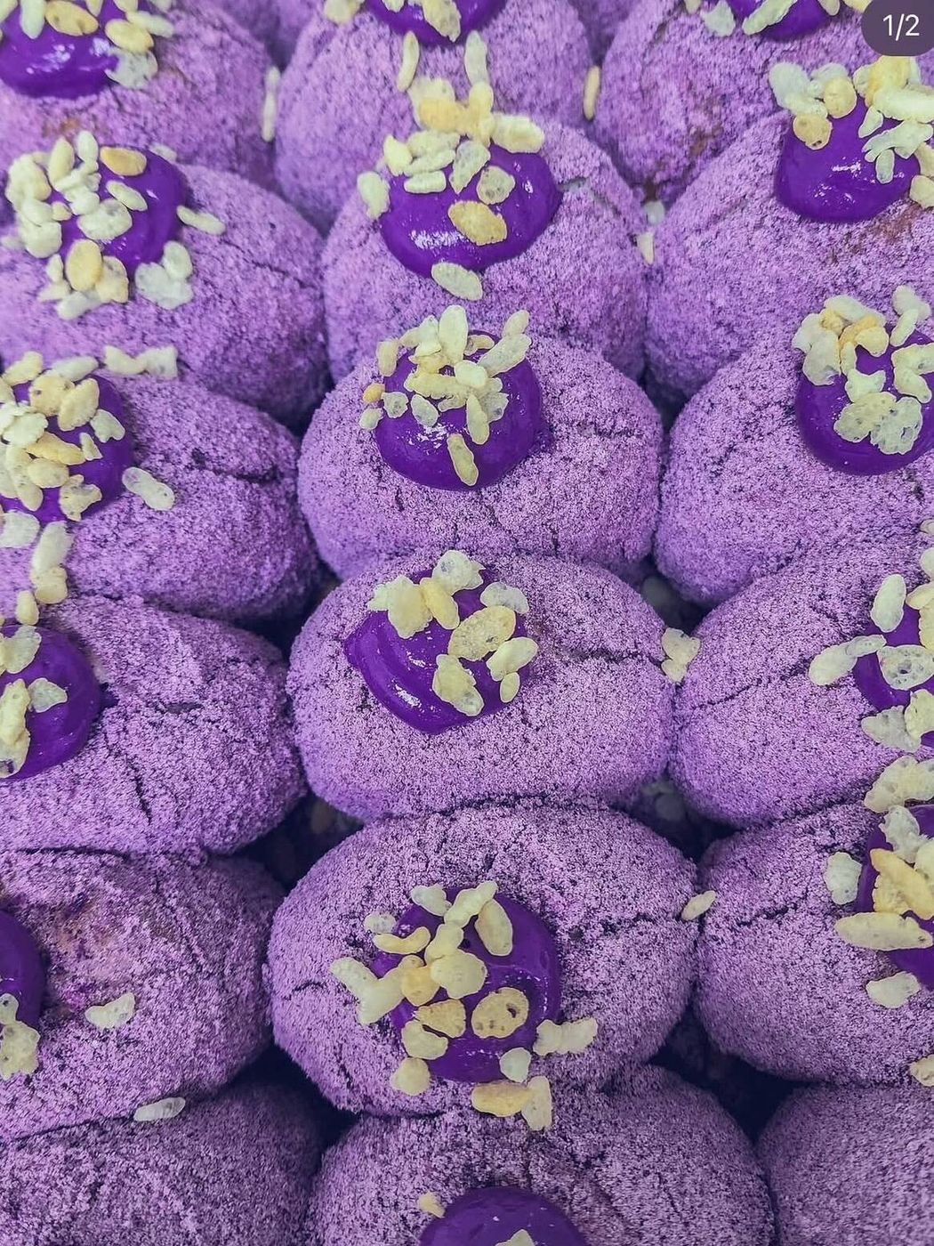A tray of ube polvoron donuts topped with purple yam cream and almonds