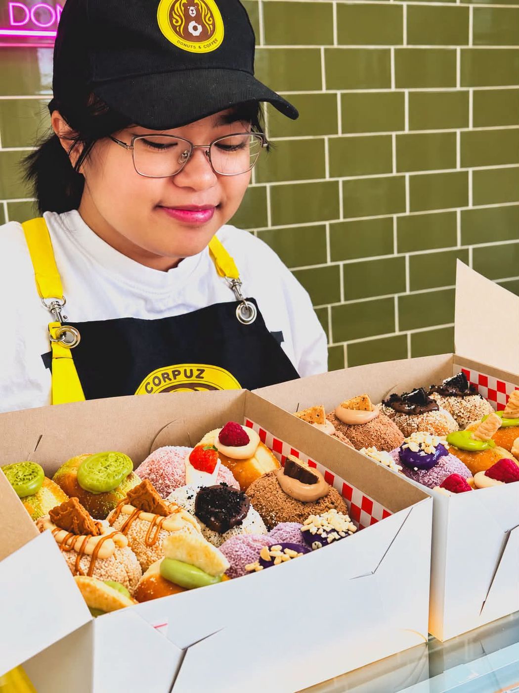 A baker with two boxes of donuts