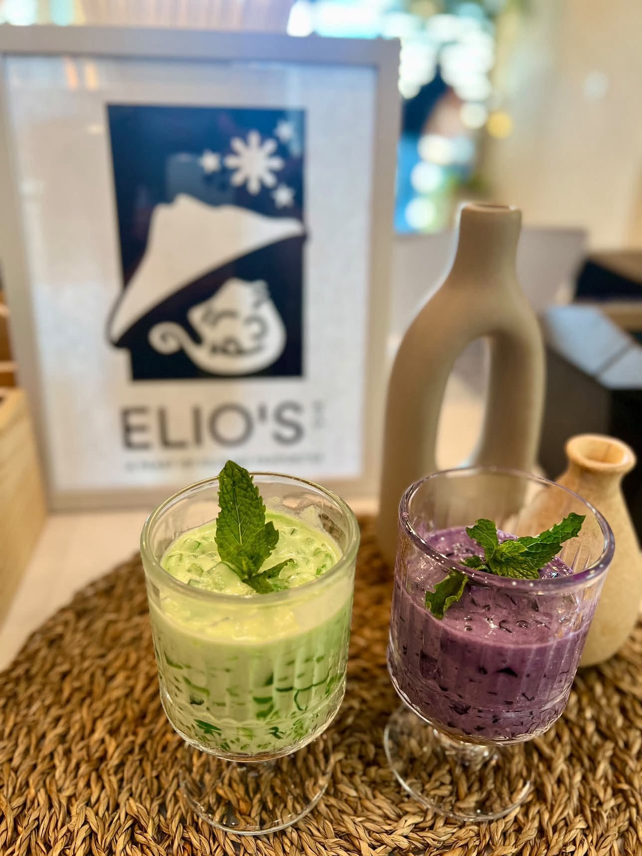Buko pandan and ube tapioca in front of the Elio's sign