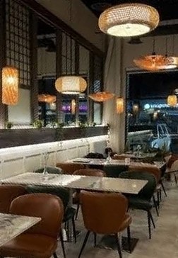 Dining room with rattan pendant lamps and leather chairs