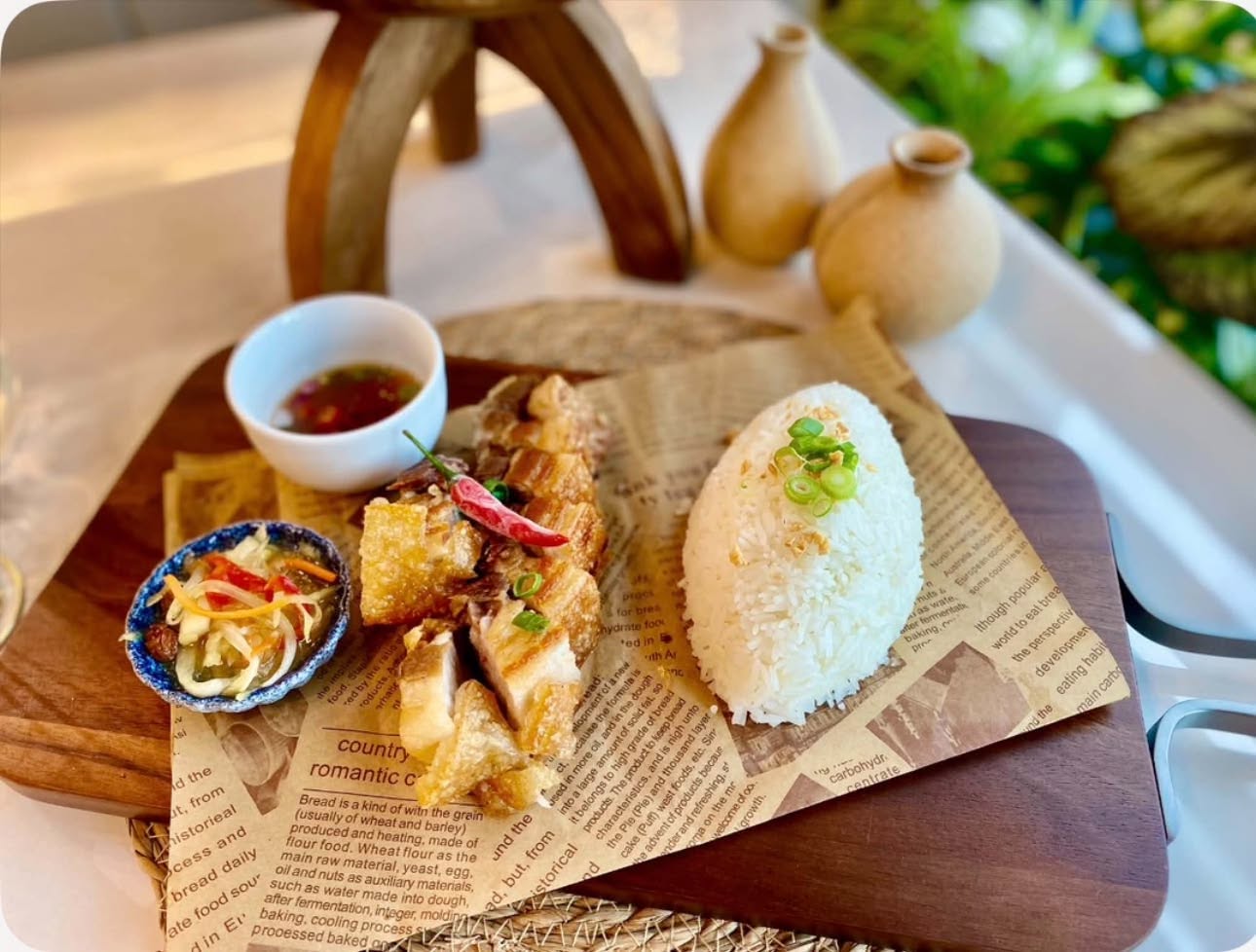 Lechon kawali with garlic rice, atchara and dipping vinegar on a wooden board